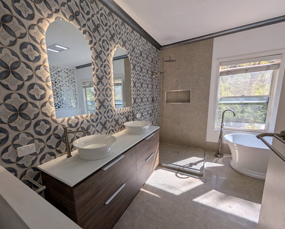 A beautiful white bath paired with a floor-standing mixer and double vanities bring both style and practicality by Star Bathrooms and Renovations.